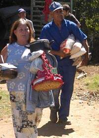 A dona de casa Maria José dos Santos carrega seus pertences: ordem de despejo acabou com 32 anos de moradia no local