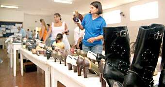 Visitantes observam sapatos à venda no 1º Megafeirão organizado pela Apae para angariar fundos