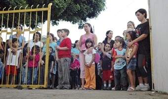 Estudantes e mães em frente de escola. Hoje, 15.600 alunos da rede municipal voltam à aulas