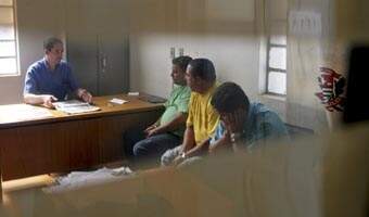 Observados pelo agente policial Paulo Nascimento, os três homens, todos de São Paulo, aguardam a hora de prestar depoimento no 1º DP: foram indiciados por estelionato e formação de quadrilha
