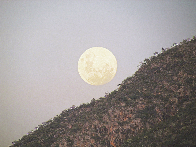É como se a lua estive logo após o morro...