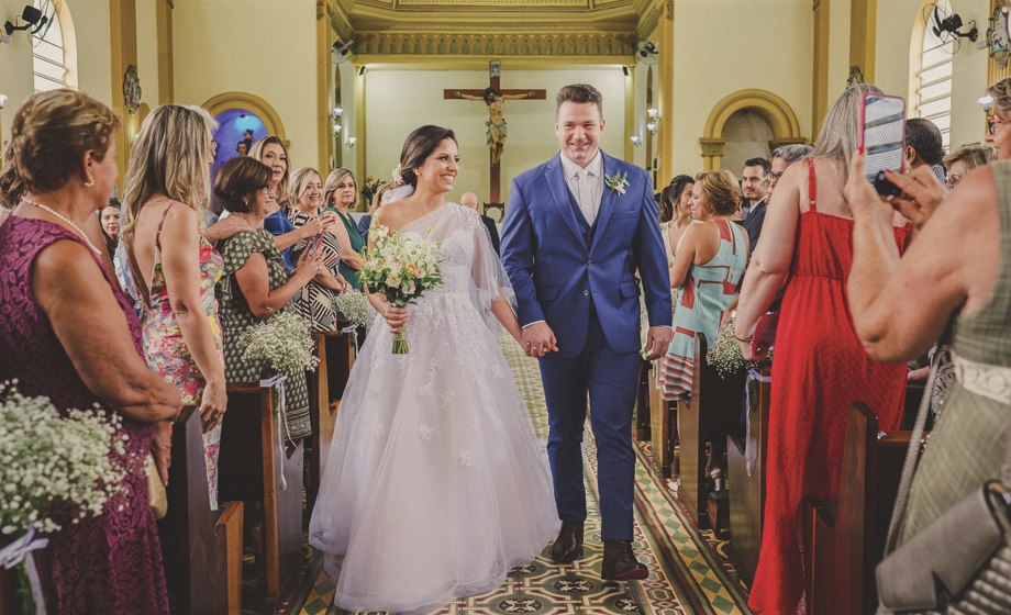 Já casados, eles vão deixando a igreja, sob os olhares dos convidados