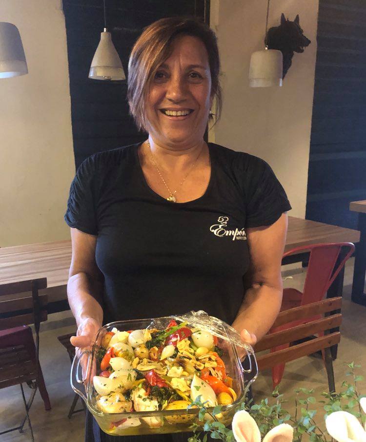 A chef Elis do Val exibindo um belo bacalhau à portuguesa assinado por ela, no Buffet Empório