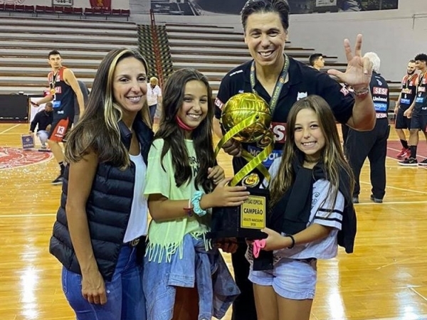 Técnico do Franca Basquete, Helinho Rubens Filho, exibindo a taça de tricampeão do Paulista 2020, com a mulher Chistiane e as filhas Maitê e Luma