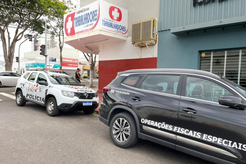 Viaturas da Polícia Militar e da Secretaria da Fazenda, em farmácia na avenida Presidente Vargas