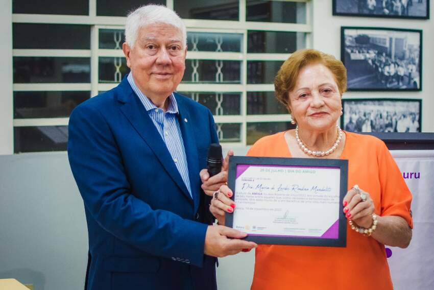 Na foto, temos Maria de Lurdes Rondina Mandaliti recebendo o certificado. 