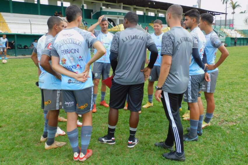 Viola (de costas no centro) conversa com jogadores da Francana durante treino