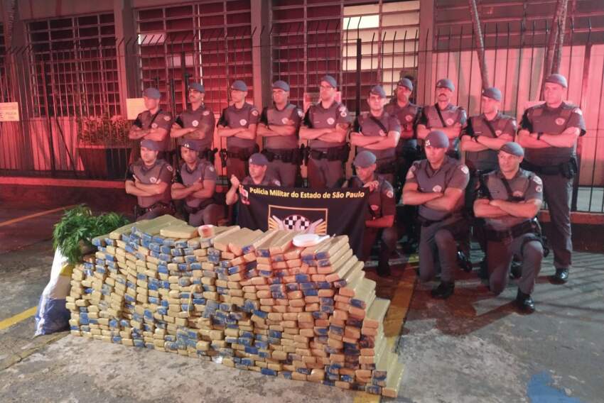 Policiais militares com os 410 tijolos de maconha apreendidos