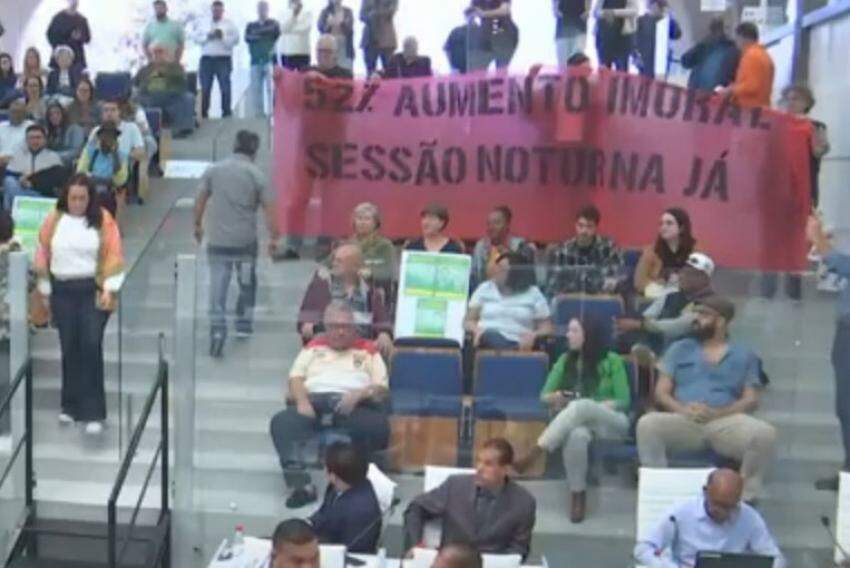 Munícipes que ocuparam plenário seguravam faixa em protesto ao aumento dos salários e por retorno das sessões noturnas na Casa