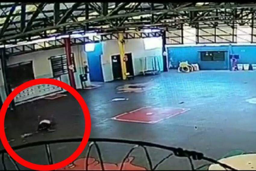 Adolescente caído no chão da quadra da escola após o acidente