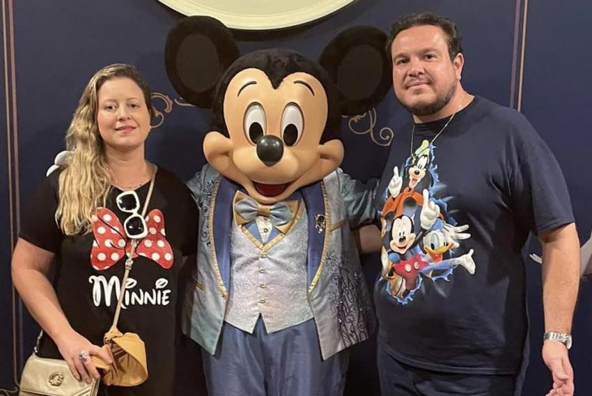 Em click com sua mulher Patrícia Fran, ladeando o personagem Mickey Mouse, na Disney, está Carlos Junior