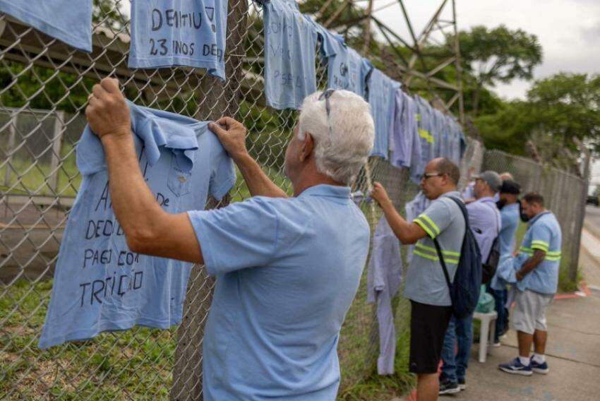 Demitidos penduram uniformes em frente à GM, em São José
