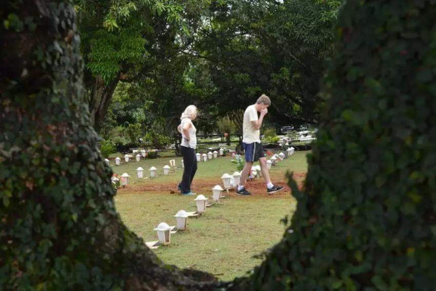 Casal passando por túmulos em cemitério