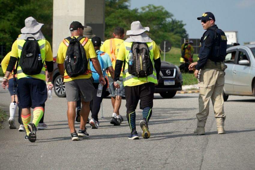 Inspetor da PRF orienta peregrinos caminhando pela Via Dutra em direção a Aparecida