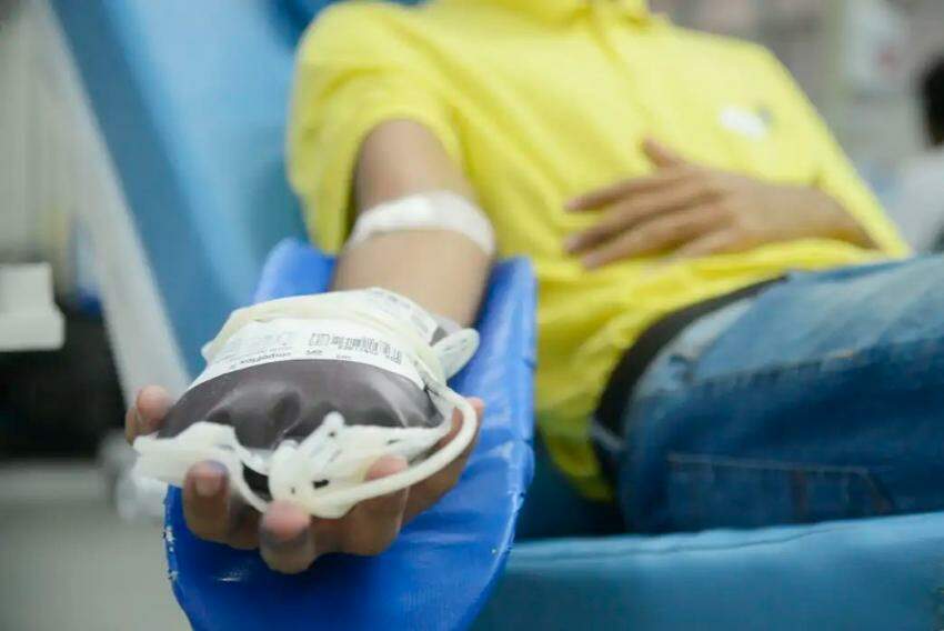 Homem segurando bolsa de sangue após doação