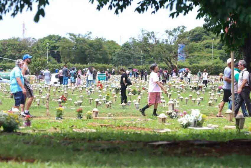 Público visitando lápides de entes em cemitério