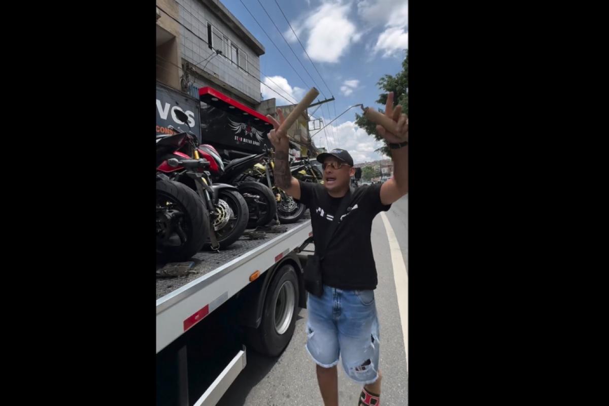 Diogo ao lado de caminhão com as motos para serem entregues em Guará