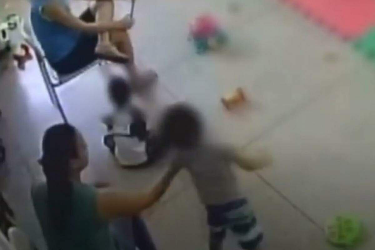 Imagem do trecho em que  mulher agarra criança pelo braço e a atira contra o chão em creche em Votuporanga