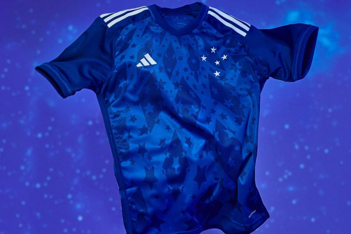 A camisa traz dois tons de azul e múltiplas estrelas no tecido, representando a constelação de conquistas do Cruzeiro.