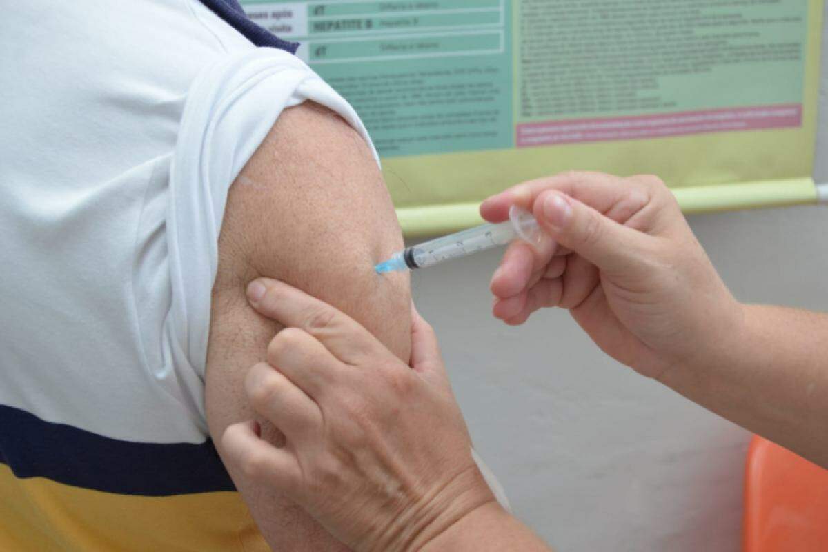 Homem sendo vacinado em posto de saúde 