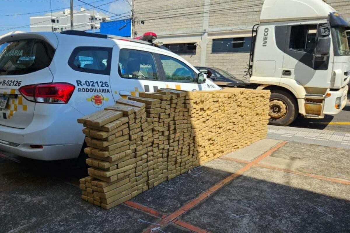 Droga, que somou mais de 1 tonelada, estava dividida entre 907 tabletes escondidos na cabine do caminhão (atrás), que também foi apreendido