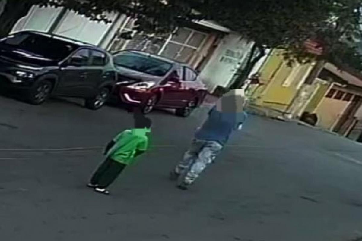 A criança, desesperada, assiste a tudo e corre pela calçada