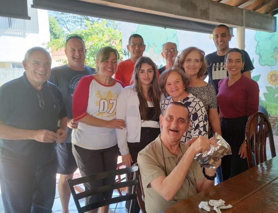 Luciana com a filha Mariana (ao centro) e membros da igreja comemorando o aniversário de Nélio Garcia (à frente) (crédito: Arquivo pessoal)