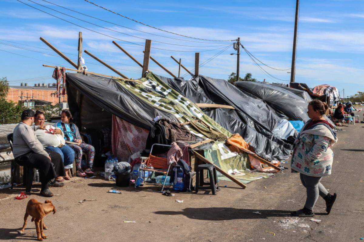 Moradores da Vila Santo André, divisa de Porto Alegre e Canoas, montaram acampamento na rodovia enquanto esperam que a água que invadiu suas casas baixe