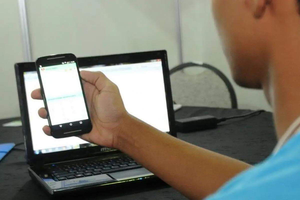 Jovem acessa a internet com celular e notebook: nesta sexta-feira, 12, o problema continua em algumas casas