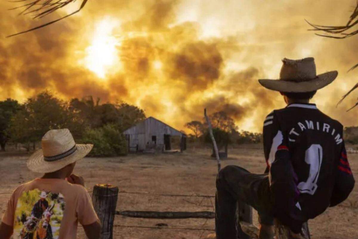 Homens observam incêndio incontrolável