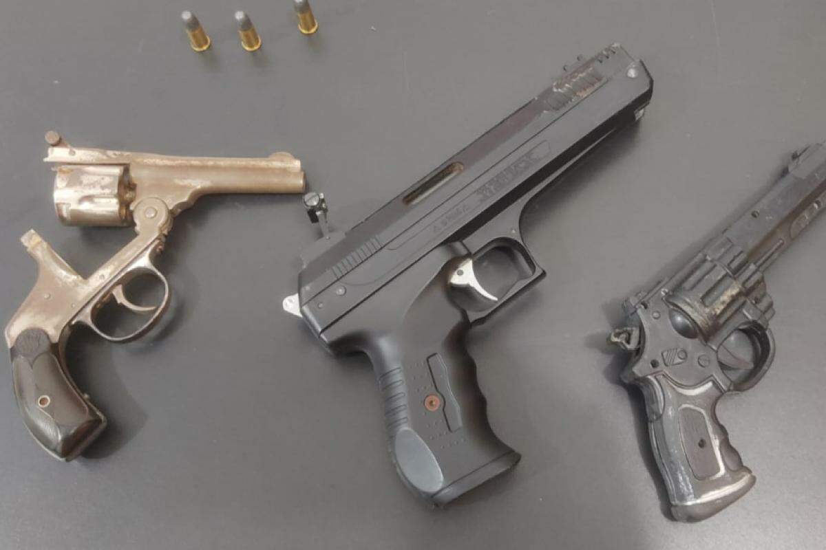 Revólver calibre 32 com três cartuchos picotados e simulacros de arma de fogo
