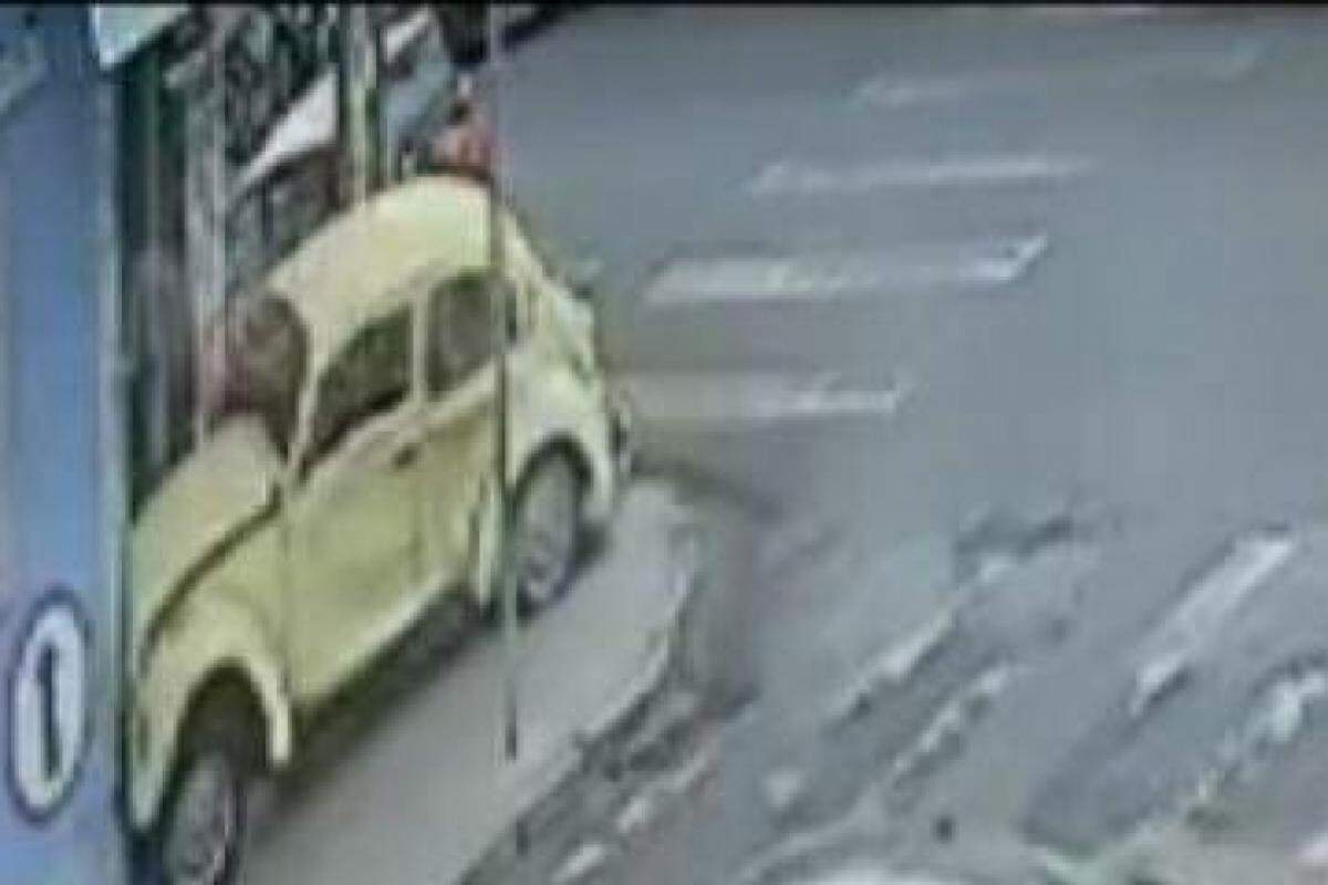 Momento em que o Fusca invade a calçada e colide com a porta da autoescola