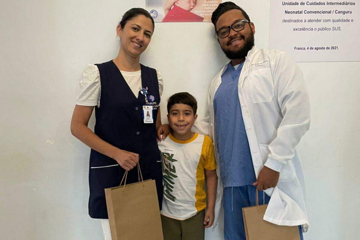 O pequeno Marcelo com a enfermeira Naiara Marques e o médico Marcos Breno de Oliveira Santos 