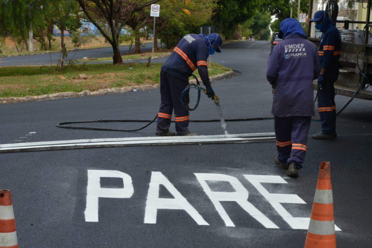 Equipes fazendo sinalização em rotatória do bairro 