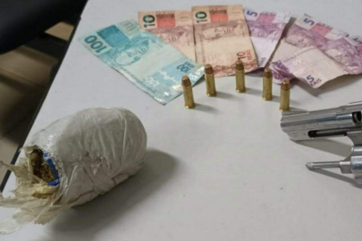 Durante busca pessoal foram localizados em sua bolsa tiracolo, um revólver Cal.38, com numeração suprimida, cinco munições intactas, uma porção de maconha 