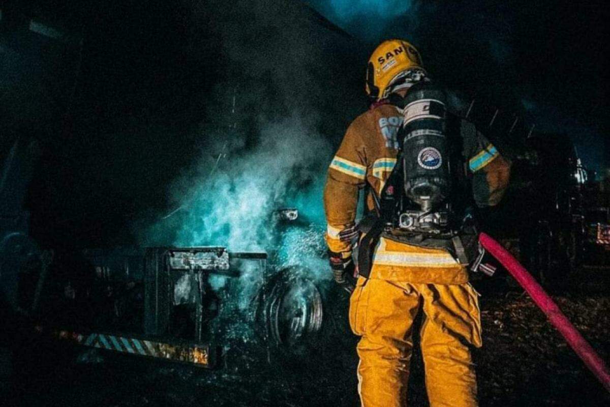 Bombeiro apaga as chamas do caminhão de leite na noite desta terça-feira, 16