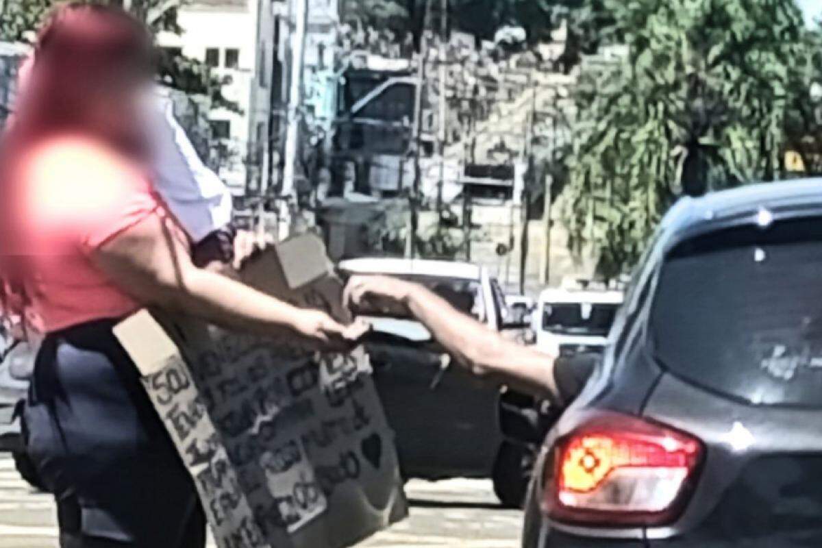 A mulher segurava um cartaz com a criança no colo no semáforo da avenida Independência 