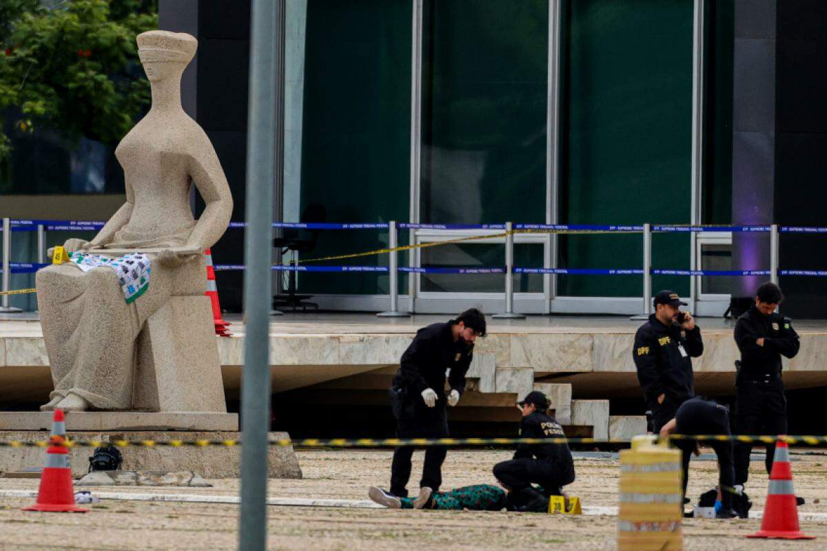 Policiais periciando o corpo de Francisco Wanderley Luiz, 59 anos, é retirado da frente do STF