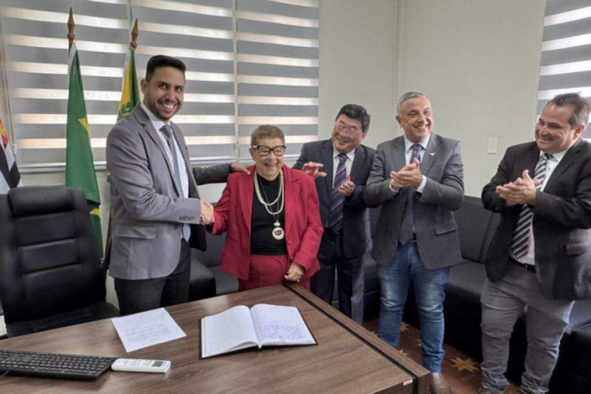 Vereadora Catini ao lado de colegas após assinar livro de posse 