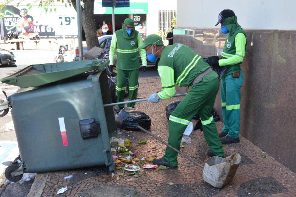 Equipe limpando caçamba de lixo no Centro de Franca