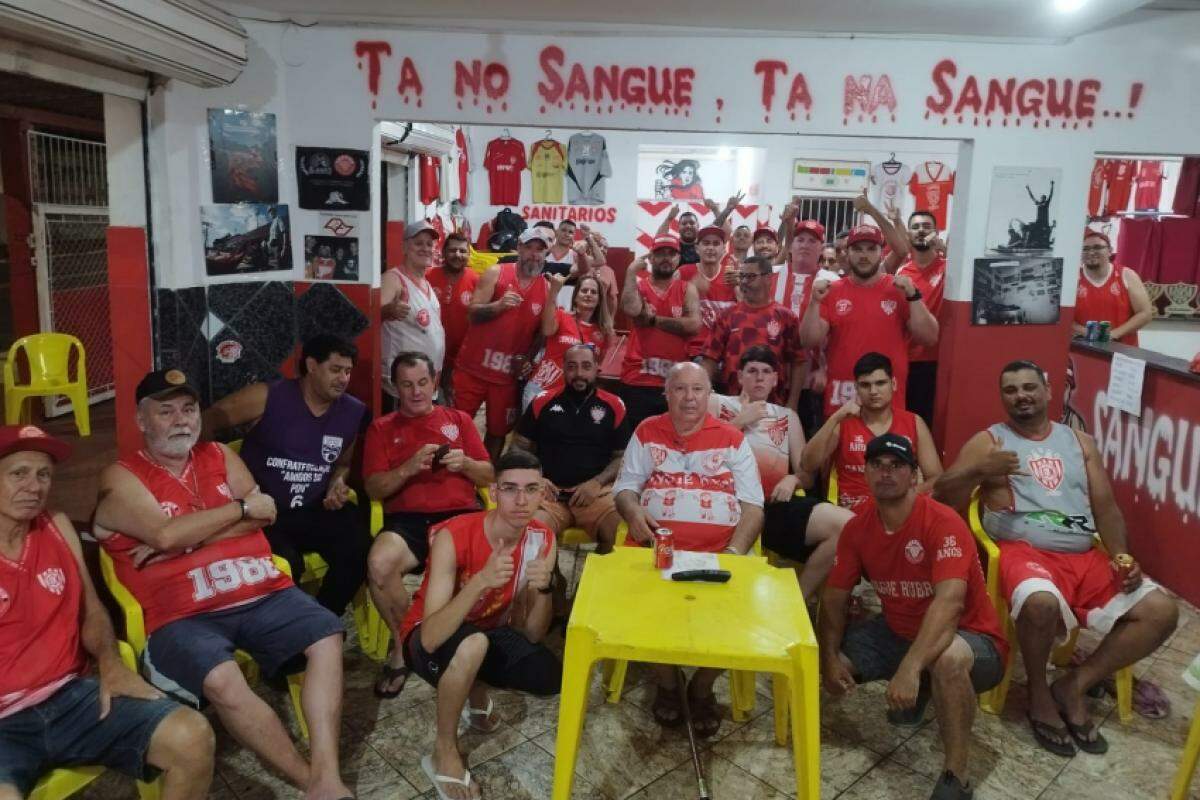 Torcedores de Bauru concentrados na sede da Sangue Rubro, assistindo à transmissão ao vivo do sorteio do Paulistão