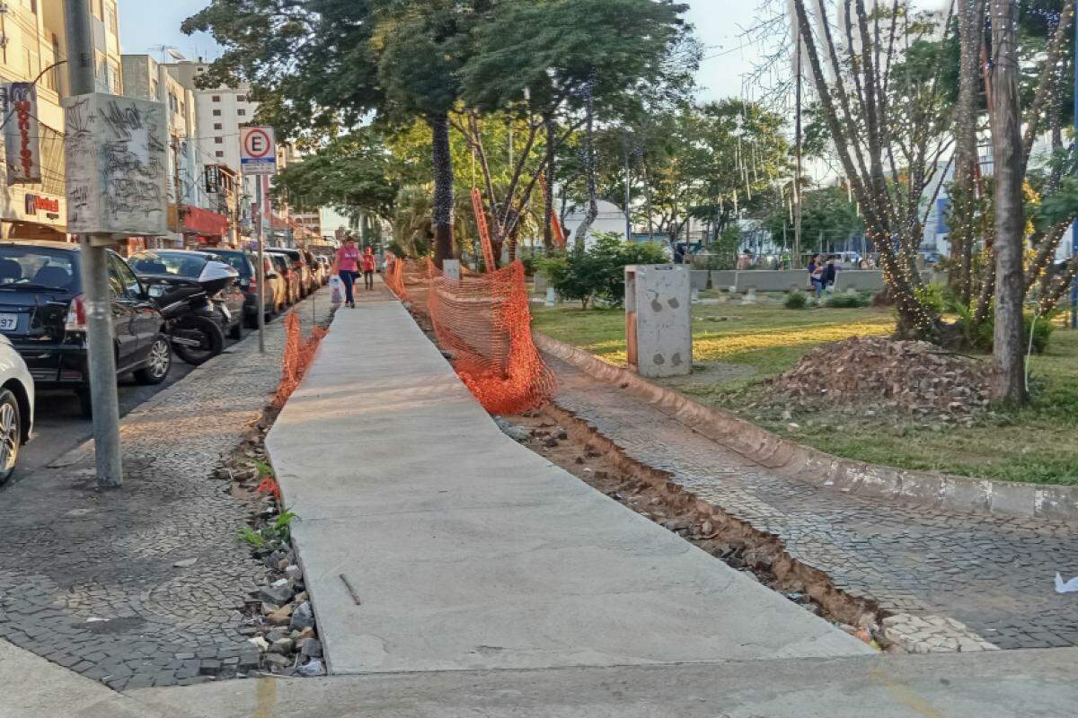 Calçada segue em construção, com pedras soltas e entulhos visíveis