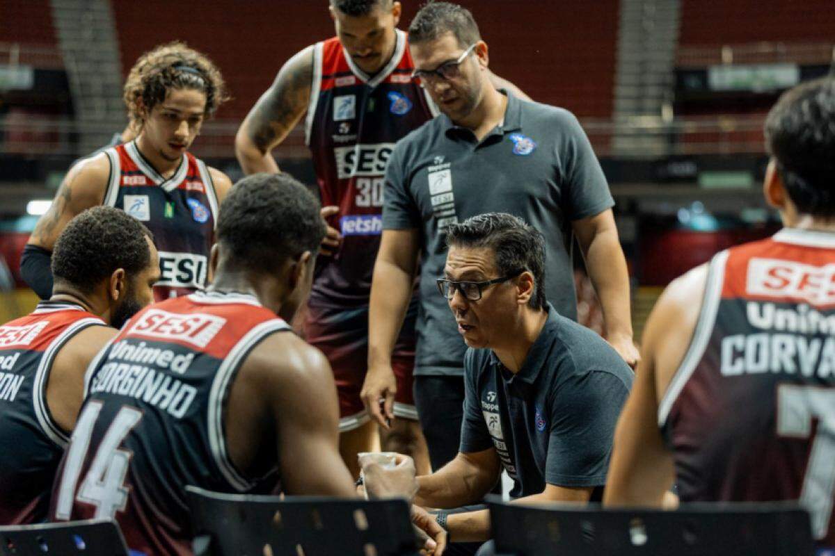 Técnico Helinho Garcia passando instruções para os jogadores durante partida contra o Minas