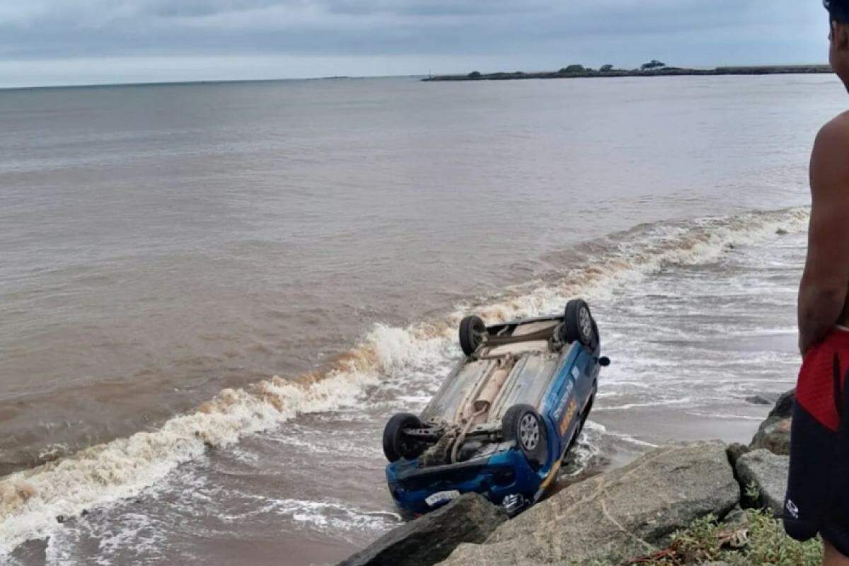 A aluna, nervosa, colidiu com um carro estacionado, capotou e caiu com o veículo na faixa de areia.