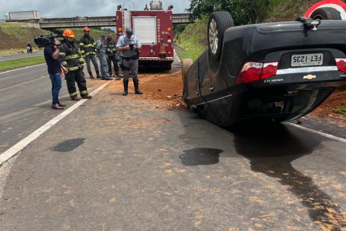 Veículo Chevrolet Cruze capotado, e equipes do Corpo de Bombeiros e Polícia Militar no local do acidente