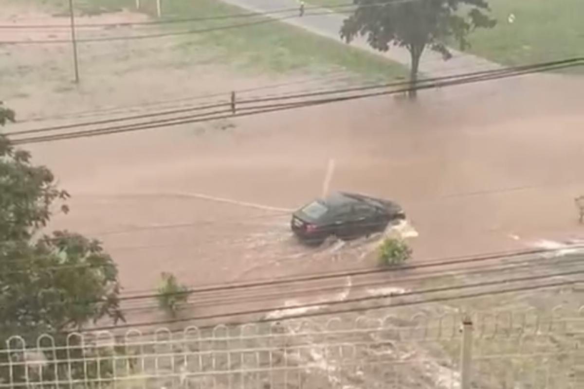 Carro atravessando a rua alagada no Parque do Povo