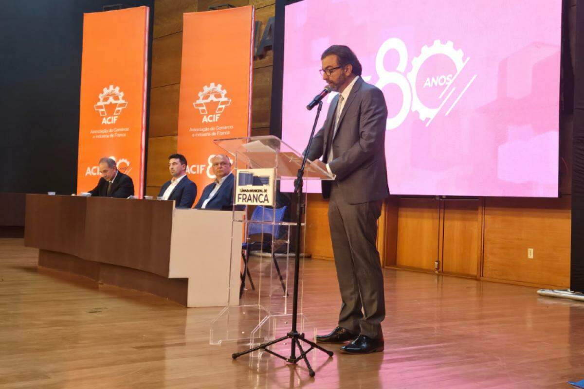 Fernando Rached Jorge durante discurso; mesa diretora ao fundo: Alexandre Ferreira, Daniel Bassi e Paulo Benintendi Zamikhowsky.