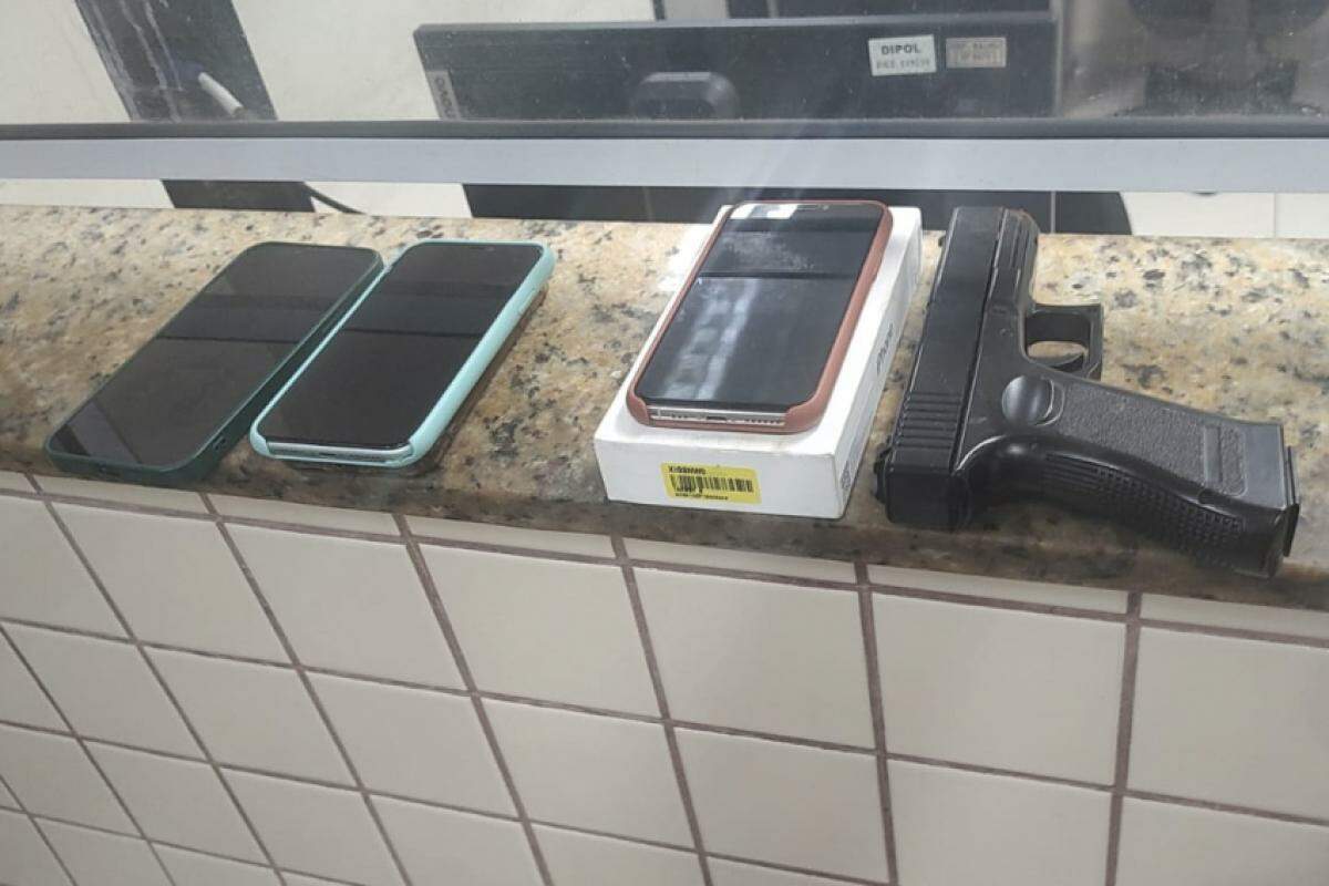 Os dois celulares recuperados e um simulacro de arma apreendido