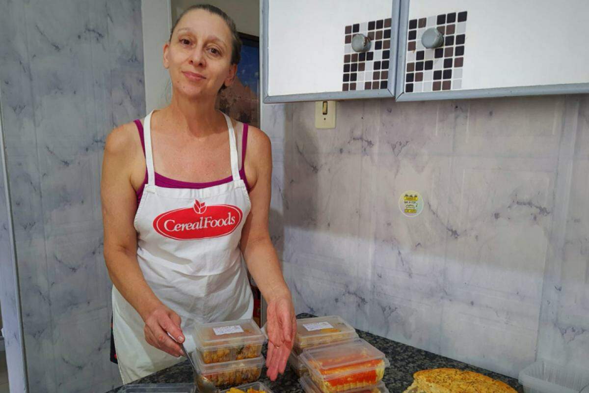 Cozinheira Tânia Nucci prepara marmitas congeladas com o auxílio do filho nutricionista