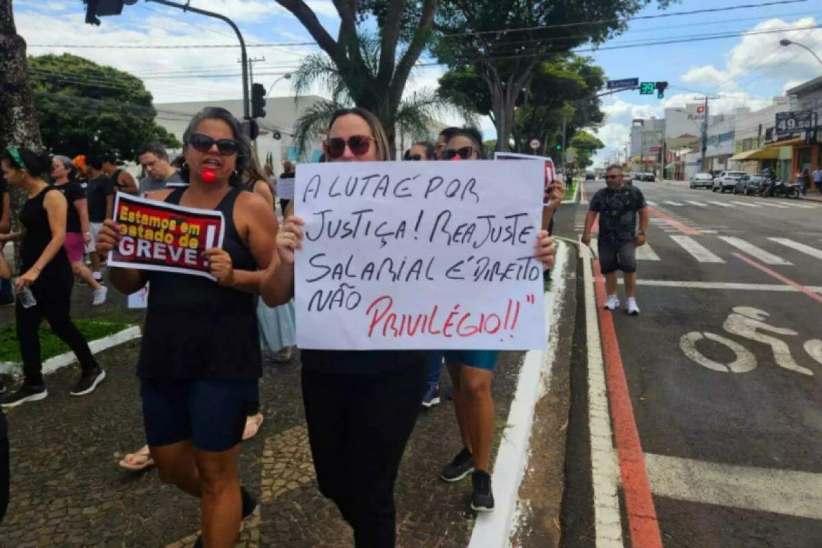 Servidores carregando cartazes durante a manifestação